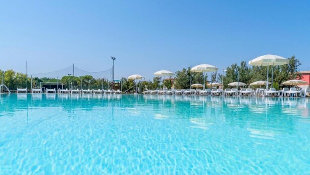 A clear swimming pool with lounge chairs and umbrellas, surrounded by trees and a clear sky. - M348 - Marcelli, comfortable new three-room apartment with swimming pool and bal (Numana)