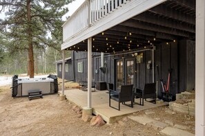 Un espace extérieur aménagé, abrité et doté de chaises et d’un jacuzzi.