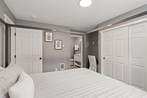 A bedroom with a large bed, two doors, a closet, and a bathroom visible through an open door. - Abenteuer Haus in downtown Leavenworth! (Leavenworth)