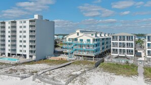 A beachfront hotel with multiple buildings, a swimming pool, and a boardwalk. - BEACH-FRONT CONDO, OUTDOOR POOL, PRIVATE BALCONY! (Gulf Shores)