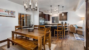 A spacious kitchen with wooden cabinets, a central island, and pendant lighting. - Gym  Hot Tub & Seasonal Outdoor Pool  Bike Trail  Parking Garage (Park City)