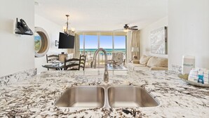 Une cuisine moderne dotée d’un grand îlot central et offrant une vue sur l’océan.