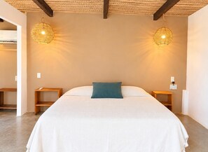 A bedroom with a bed, two bedside tables, and two wall-mounted lamps. - El Eden Escondido (Puerto Escondido)