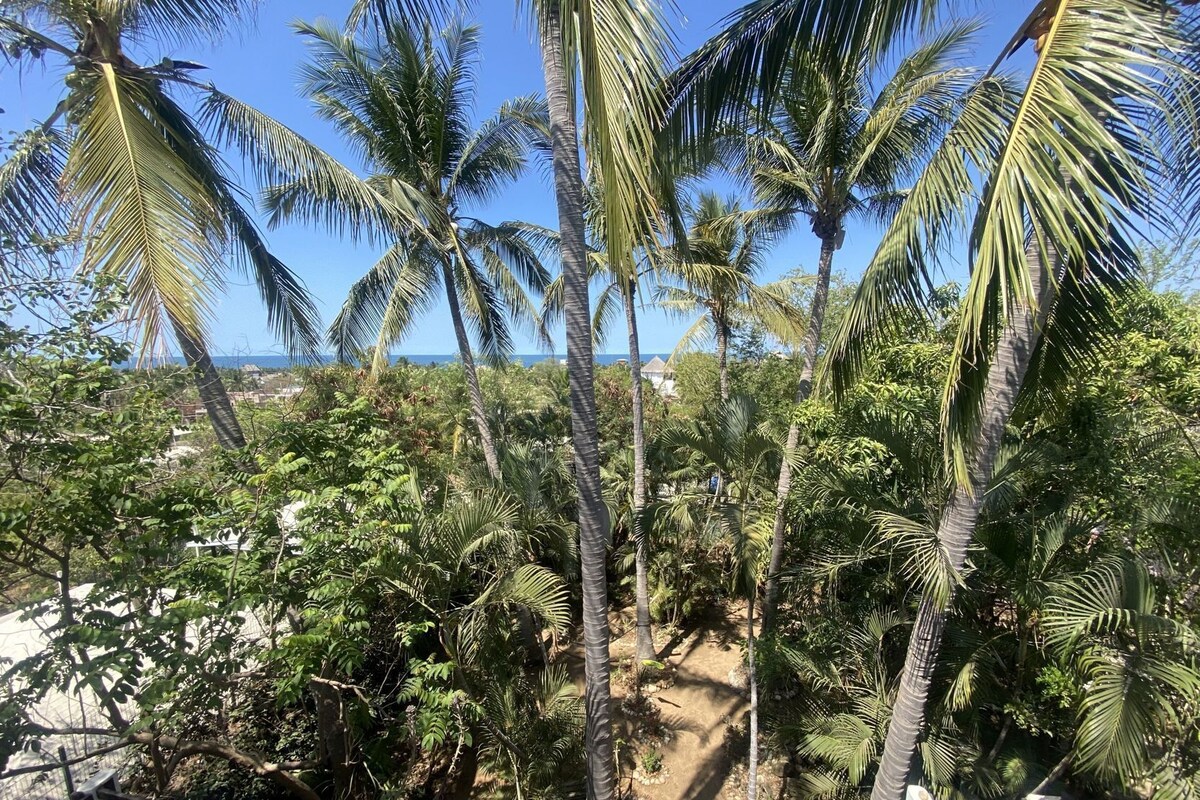Un paysage tropical avec des palmiers et un sentier de terre.