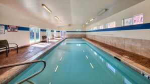 An indoor swimming pool with clear water, benches along the sides, and a lifeguard warning sign. - New Listing: Private Spa | Sunroom | Pool | Garage | Close to Parks | C347 (Moab)