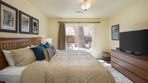 A bedroom with a large bed, a TV, a dresser, and framed pictures on the wall. - New Listing: Private Spa | Sunroom | Pool | Garage | Close to Parks | C347 (Moab)