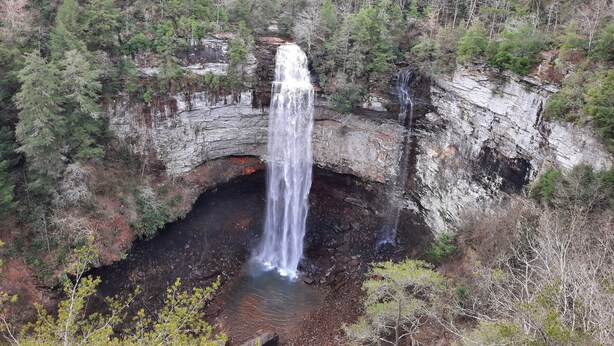 A waterfall cascading into a rocky basin surrounded by dense forest. - Lake View Adventure Cabin at Bear Bluff Retreat (Walling)