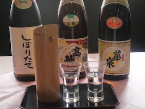 Three bottles of Japanese sake and two shot glasses on a tray. - Minshuku Miyake (Tsuwano)