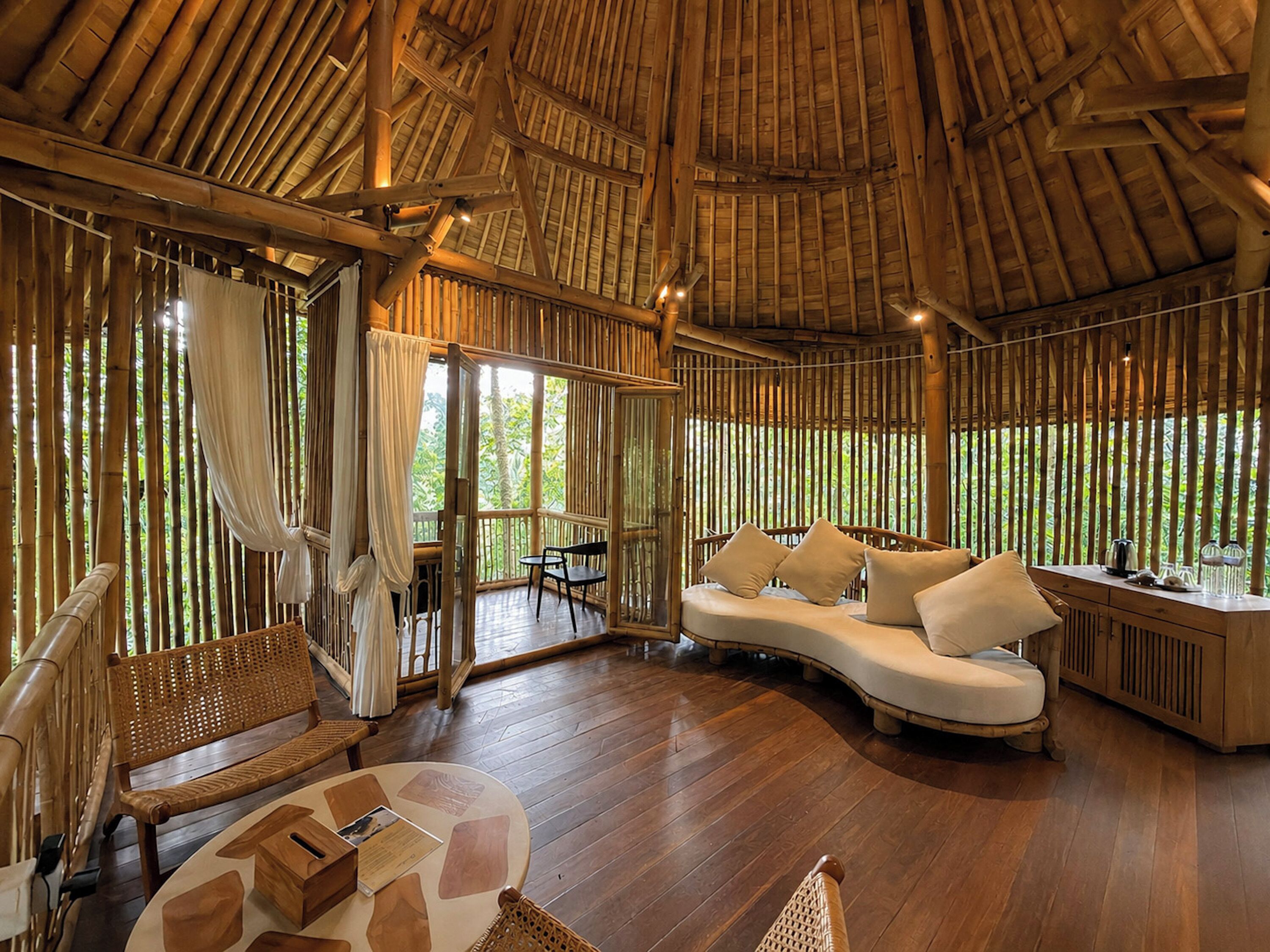 A room with a curved sofa, a wooden table, and a bench.