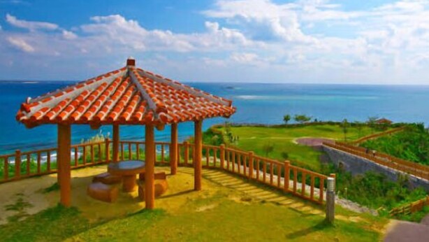 A gazebo with a tiled roof, a wooden fence, and a view of the ocean. - Villa Gazamani (Yaese)