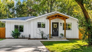 A single-story house with a front porch, a front door, and a small front yard.