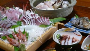 Verschiedene Fischgerichte auf einem Holztisch.