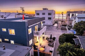 A residential area with a blue building featuring a balcony and a patio area with outdoor seating.