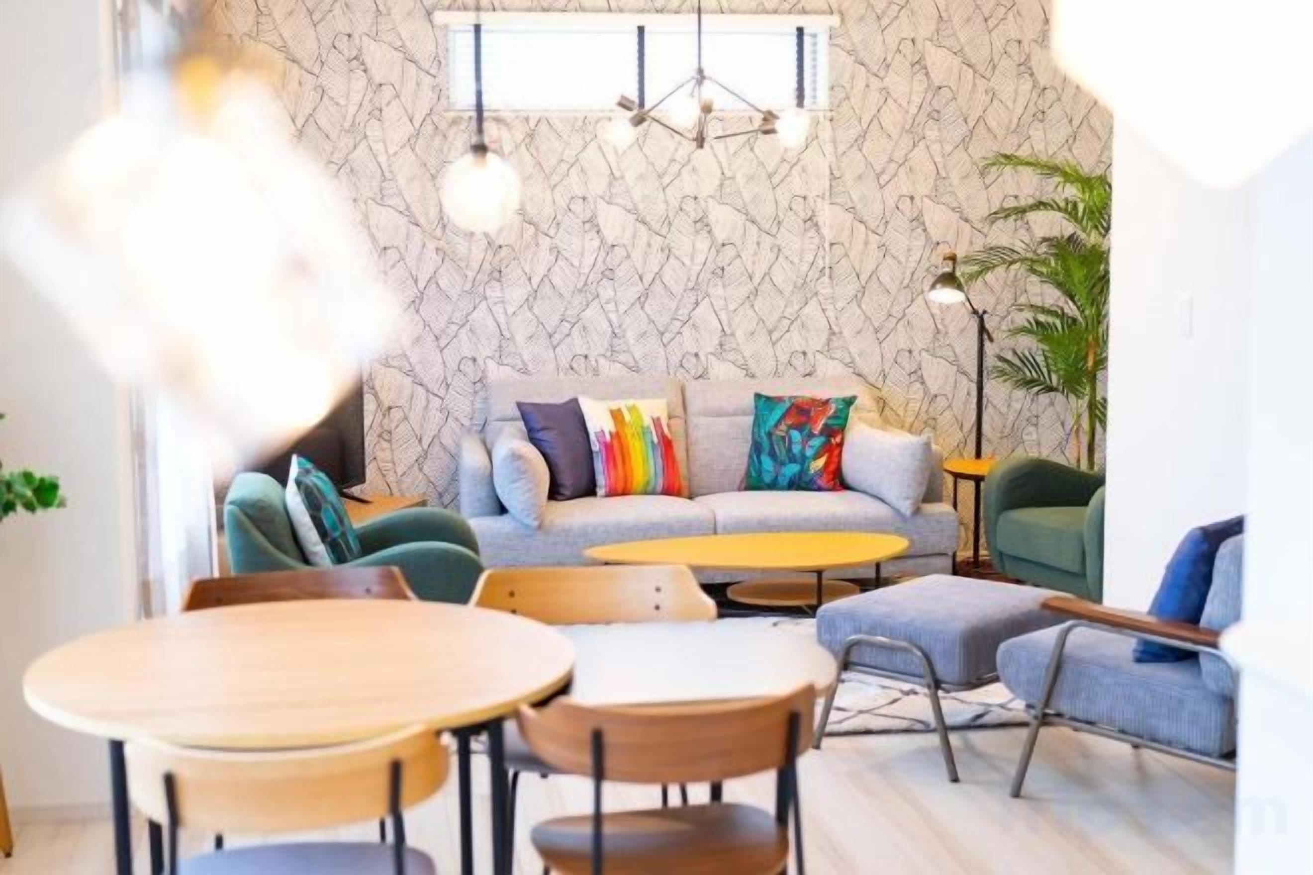 Een moderne woonkamer met een bank, stoelen, een salontafel en een eettafel.