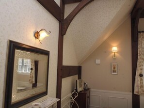 A bathroom with a large mirror, wooden beams, a wall-mounted light, and a framed picture. - British Country House Brookfield Farm (Nasu)