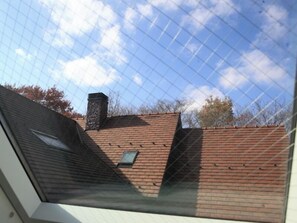 A view through a window with a brick building, a chimney, and a clear sky. - British Country House Brookfield Farm (Nasu)