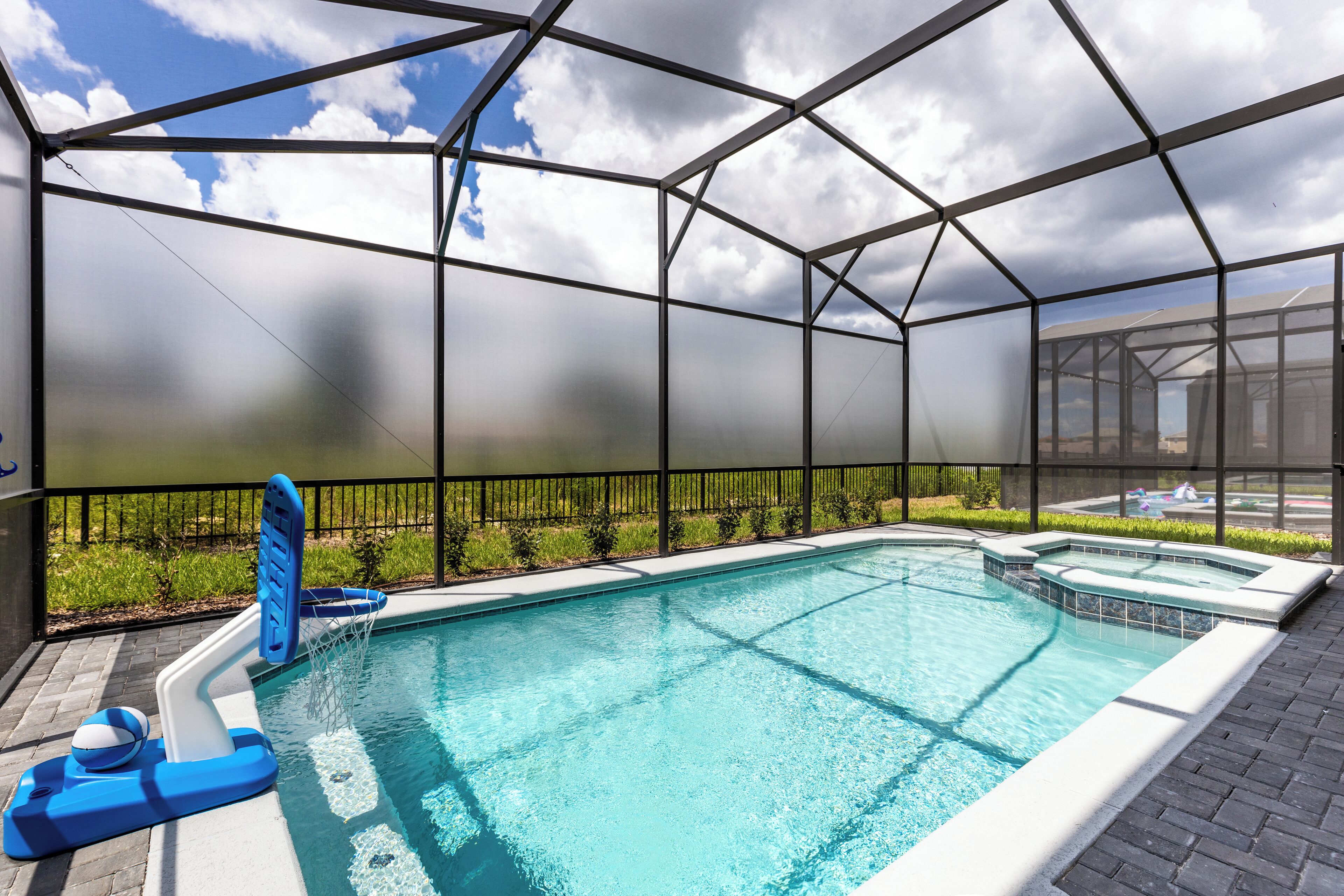 Piscina com estrutura de vidro, prancha de mergulho e cadeira do salva-vidas.