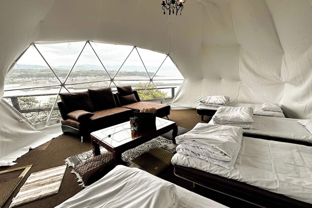 A tent with a bed, a sofa, and a table.