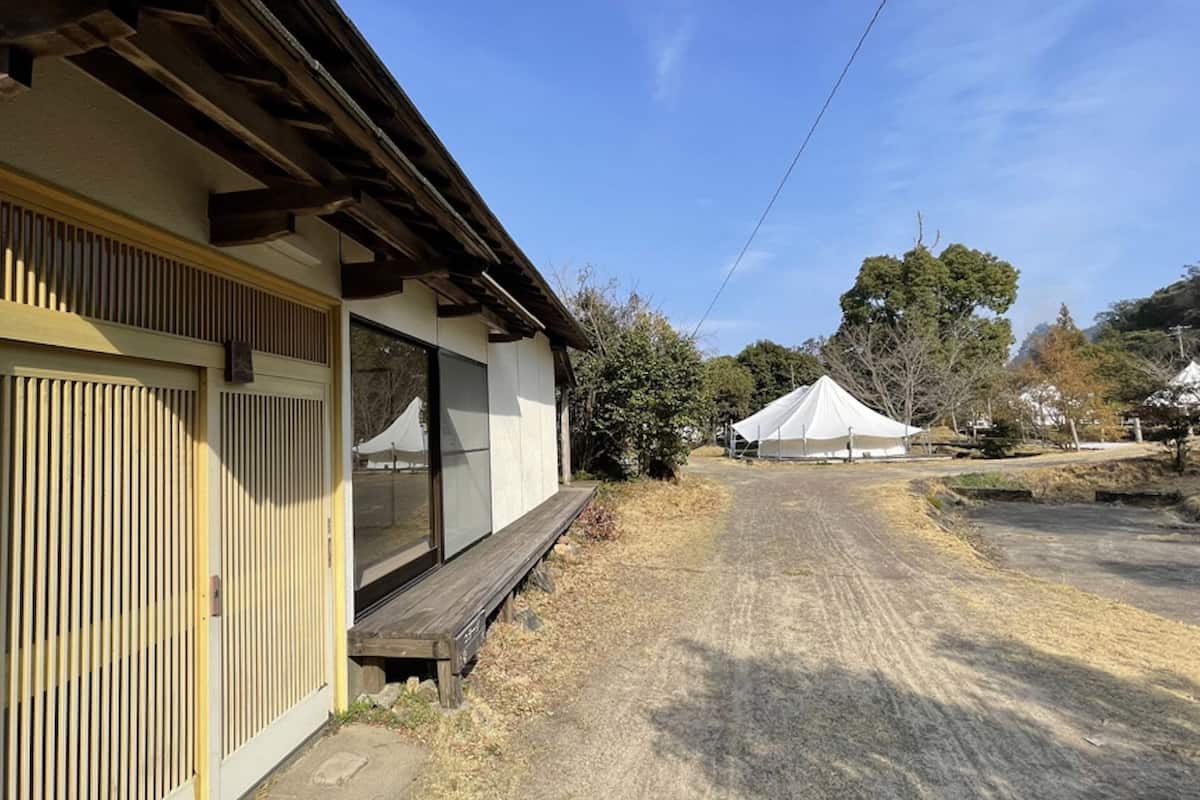 A building with a wooden deck and a covered area with a tent.