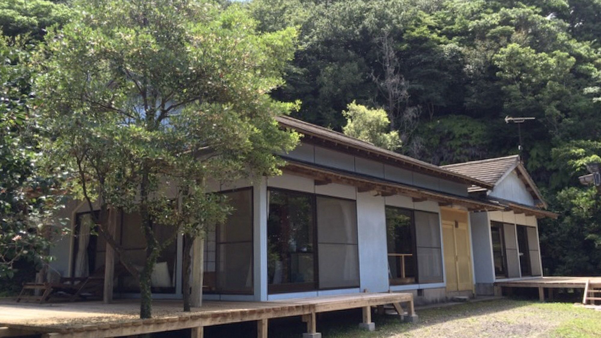 Ein traditionelles japanisches Gebäude mit großen Fenstern und einer Holzterrasse.