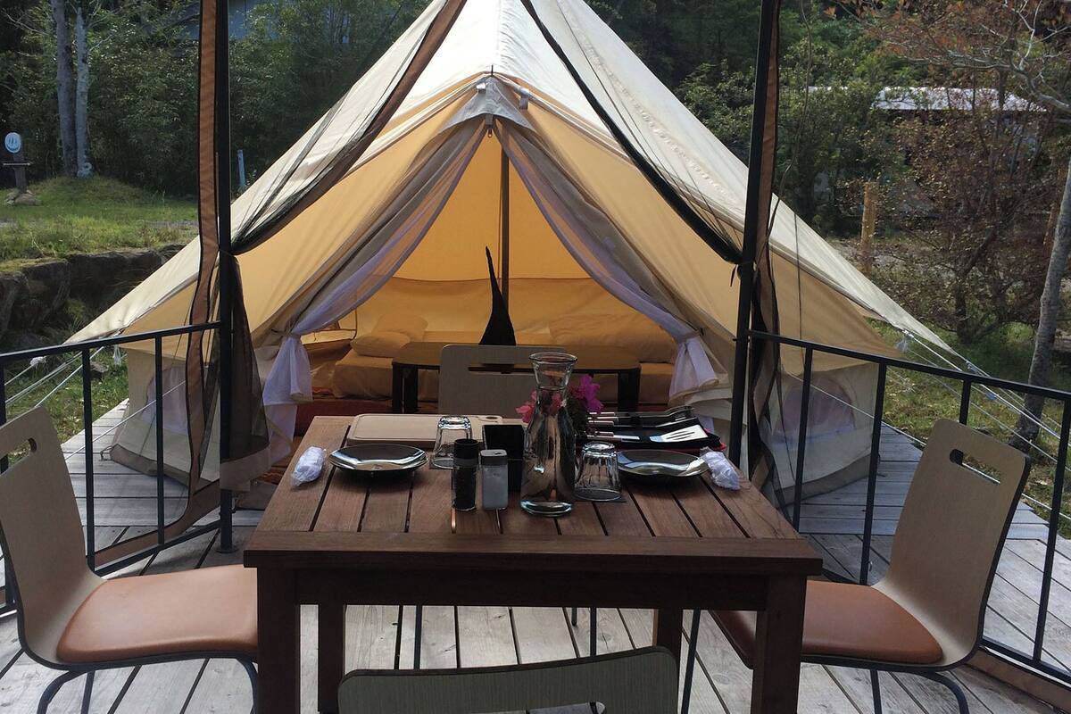 A tent with a table and chairs set up on a wooden deck.