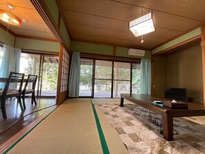 A traditional Japanese room with tatami flooring, sliding doors, a low table, and a television. - Yamamizuki (Shimanto)