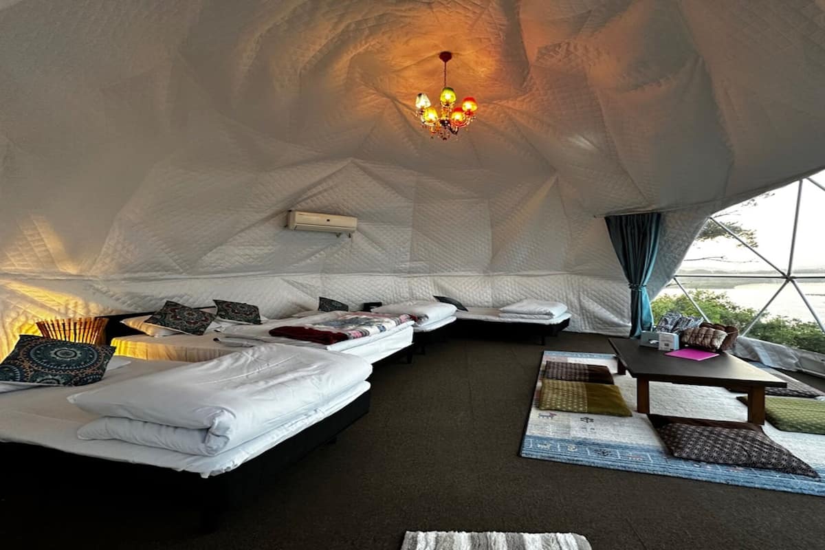 An igloo-style accommodation with a bed, seating area, and a table.