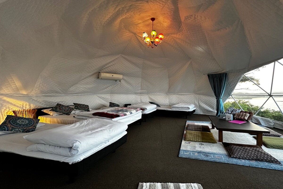 An igloo-style accommodation with a bed, seating area, and a table.