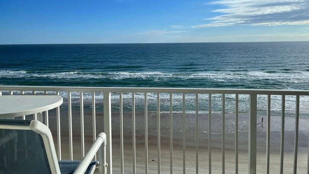 A balcony with a view of the ocean and a sandy beach. - Stunning direct oceanfront views from your own balcony! (Daytona Beach)