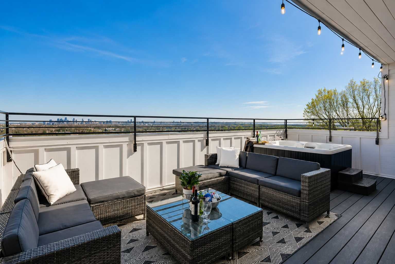 A rooftop terrace with outdoor seating, a hot tub, and a city skyline view.