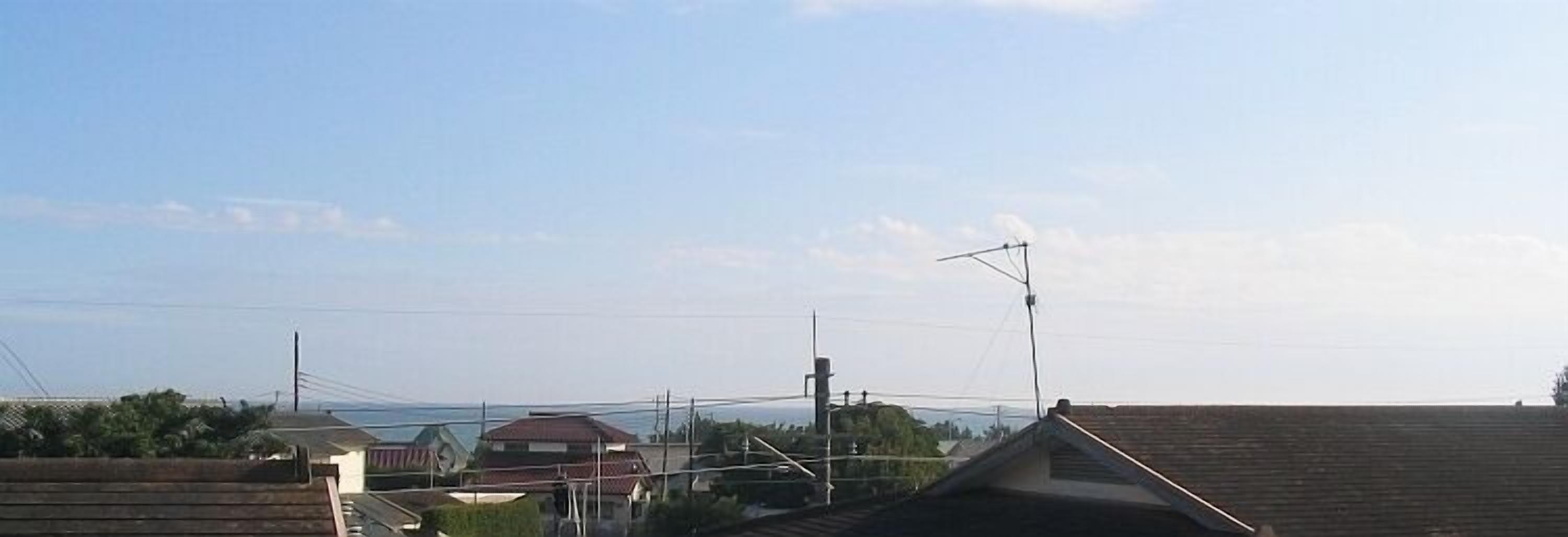 A residential area with houses, a clear sky, and power lines.