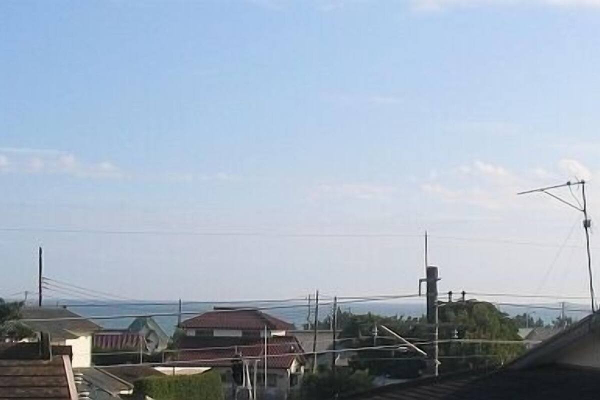 A residential area with houses, a clear sky, and power lines.