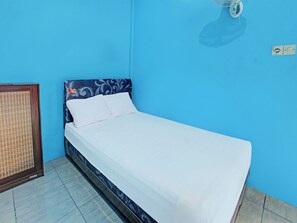 A single bed in a room with blue walls and a patterned headboard. - Spot On 91811 Rumah Inap Bunda Nurhayati (Tanak Awu)