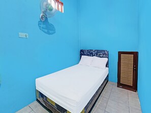 A room with a bed, a wall-mounted fan, and a door with a woven pattern. - Spot On 91811 Rumah Inap Bunda Nurhayati (Tanak Awu)
