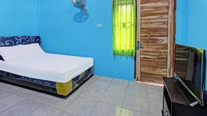 A room with a bed, a wooden door, a television, and a wall-mounted light fixture. - Spot On 91811 Rumah Inap Bunda Nurhayati (Tanak Awu)