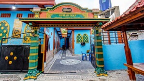 A colorful entrance with a sign reading "Rumah INAP" and a patterned floor.