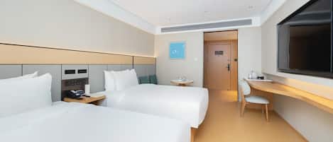 A hotel room with two beds, a desk, a chair, a TV, and a small table with a phone and a cup.