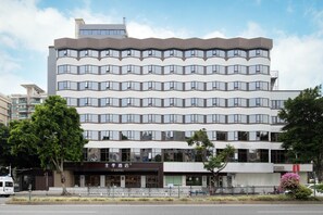 Un hôtel à plusieurs étages, doté d’une architecture moderne, avec de nombreux balcons et de grandes fenêtres.
