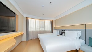 Una habitación de hotel moderna con una cama grande, mesitas de noche, un televisor de pantalla plana y una ventana con cortinas.