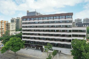 A multi-story hotel with a modern design, featuring a flat roof and large windows on each floor.