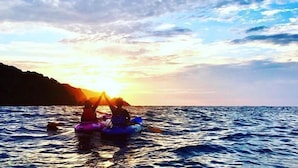 Two people in a boat on a body of water with a sunset in the background. - Sekinoya (Kami)