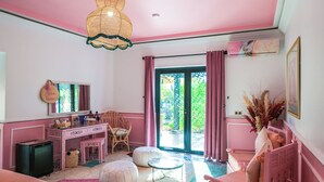 A pink-themed room with a desk, chair, ottoman, and a bed. - Maison Daouia (Marrakech)