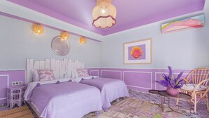 A bedroom with two beds, a decorative ceiling light, a wall-mounted mirror, and a chair with a potted plant. - Maison Daouia (Marrakech)