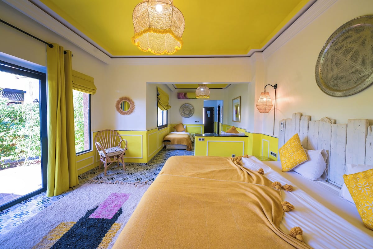A room with a bed, a chair, a desk, and a mirror.