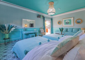 A bedroom with two beds, a dresser, a mirror, and a ceiling light. - Maison Daouia (Marrakech)
