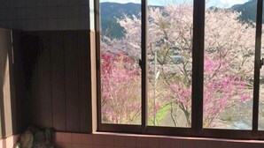 A room with a view of cherry blossoms, a small water feature, and tiled flooring. - MIZUKAMISO (Mizukami)
