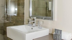 A modern bathroom with a large white sink, two glass tumblers, a mirror, and a towel rack with toiletries. - 9 On Kromellenboog Guesthouse (Metsimaholo)