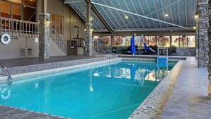 Ein Hallenbad mit Steinwand und überdachtem Bereich.