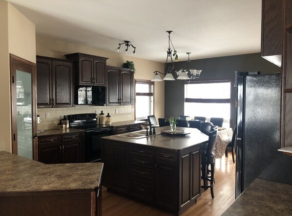 Enjoy cooking in this well-equipped kitchen with a large island, modern appliances, and a dining area.