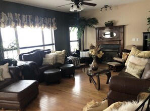 Relax in a cozy seating area with a leather sofa set, glass coffee table, and plush pillows.